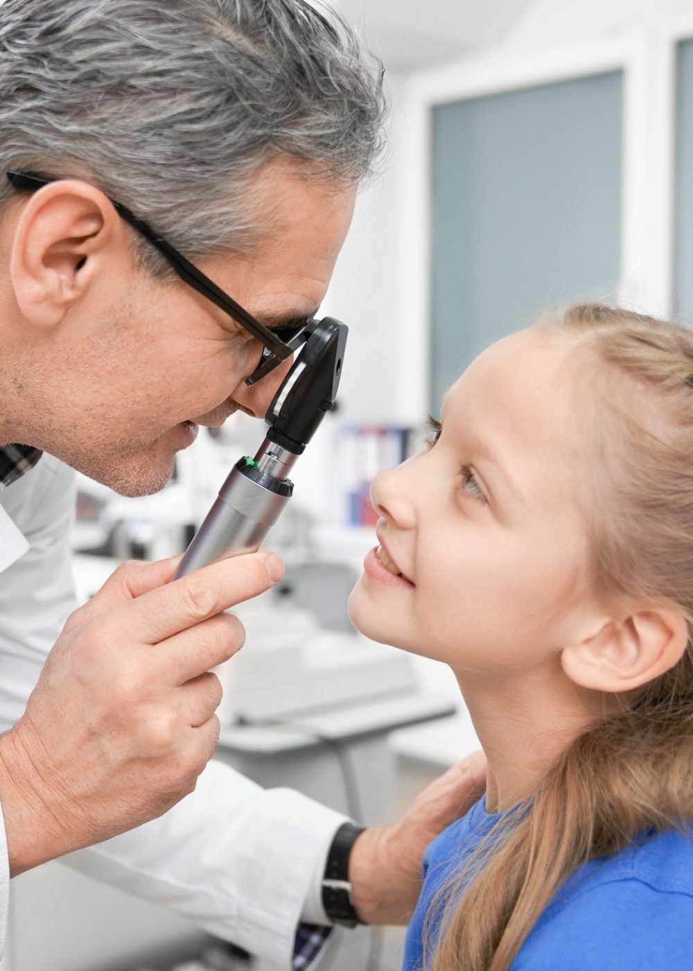 view-from-side-of-oculist-checking-sight-of-girl-in-clinic.jpg